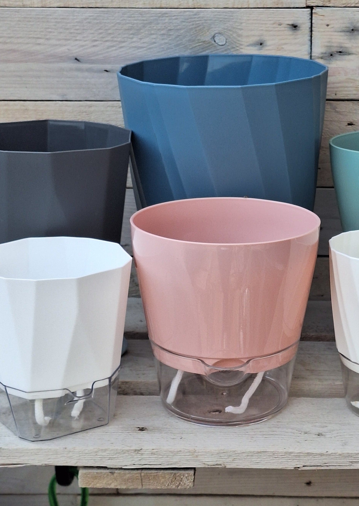 Various sized self watering plant pots in a variety of colours.